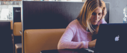 紧张的女人坐在餐厅里盯着笔记本电脑屏幕