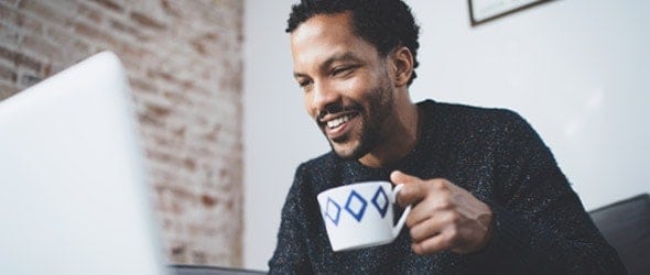 一个男人拿着一杯咖啡，面带微笑