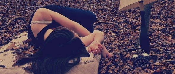 一位女士躺在铺满树叶的床上