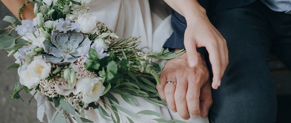 新郎手握花束的新娘。